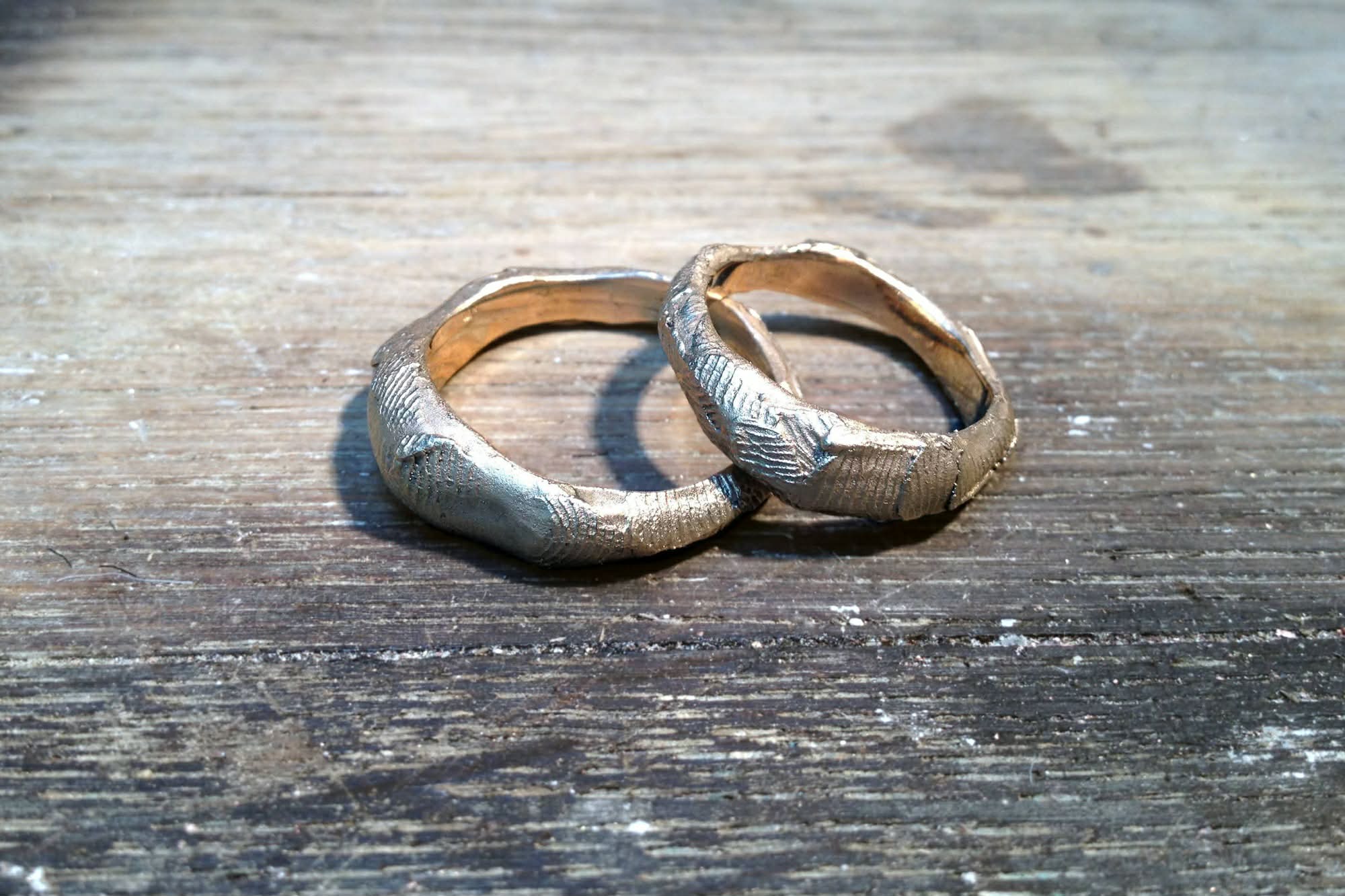 Specialbeställda vigselringar i guld. Ytan har en struktur av fingeravtryck och insidan är blankpolerad.